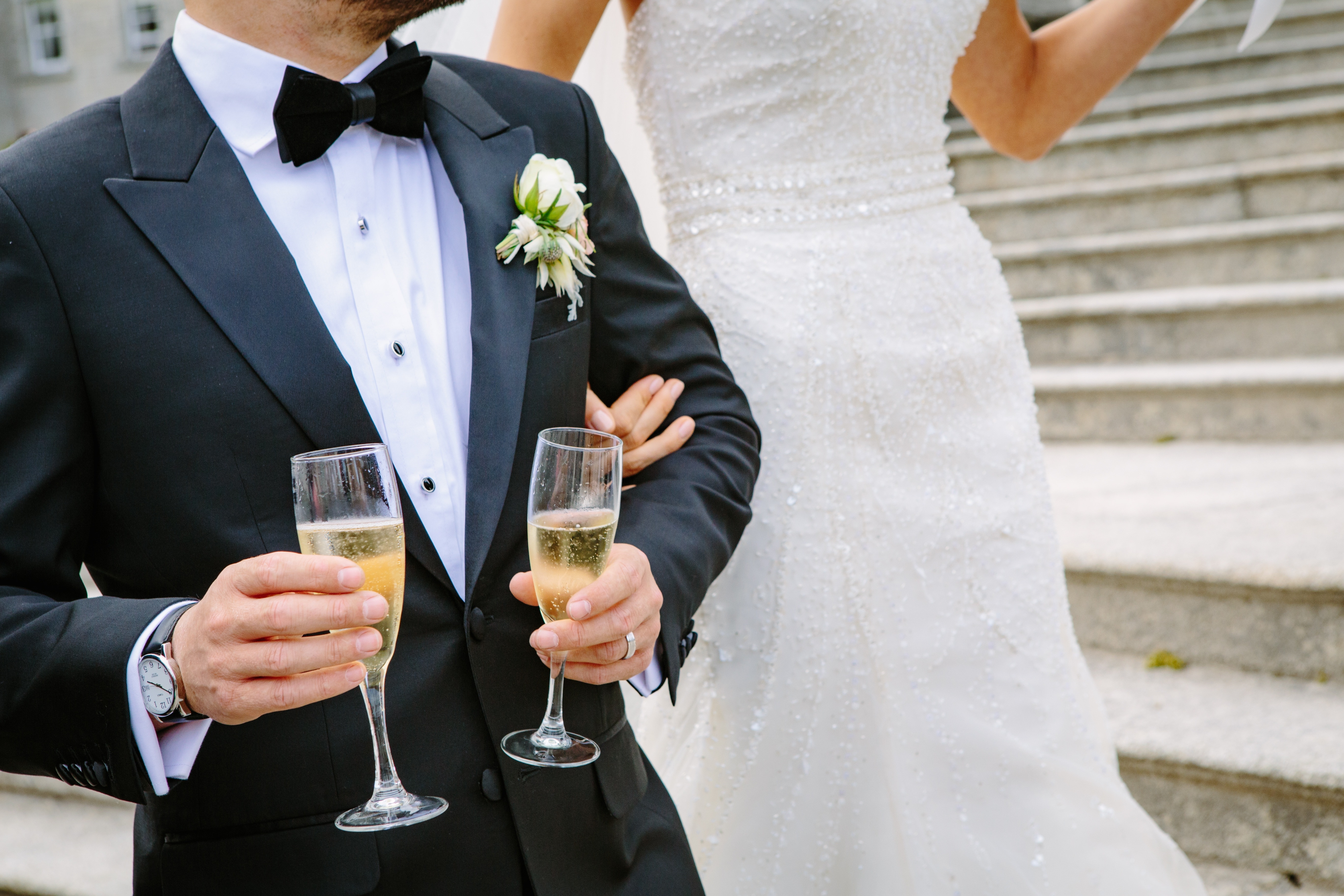 bride beside groom carrying glasses of champagne