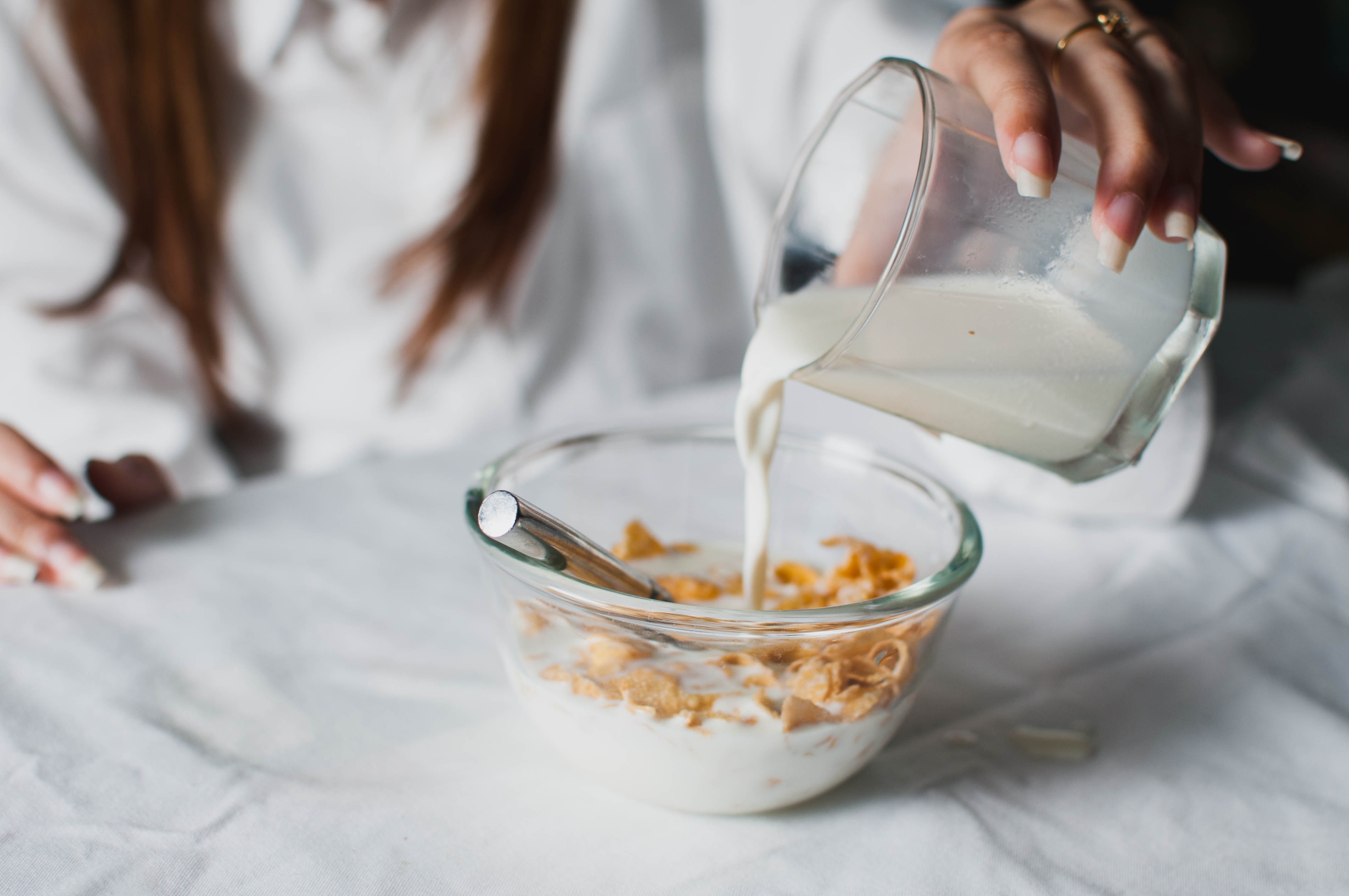 bowl of milk and cereals served on clear glass bowl