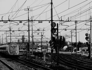 greyscale photo of bullet train and train rails thumbnail