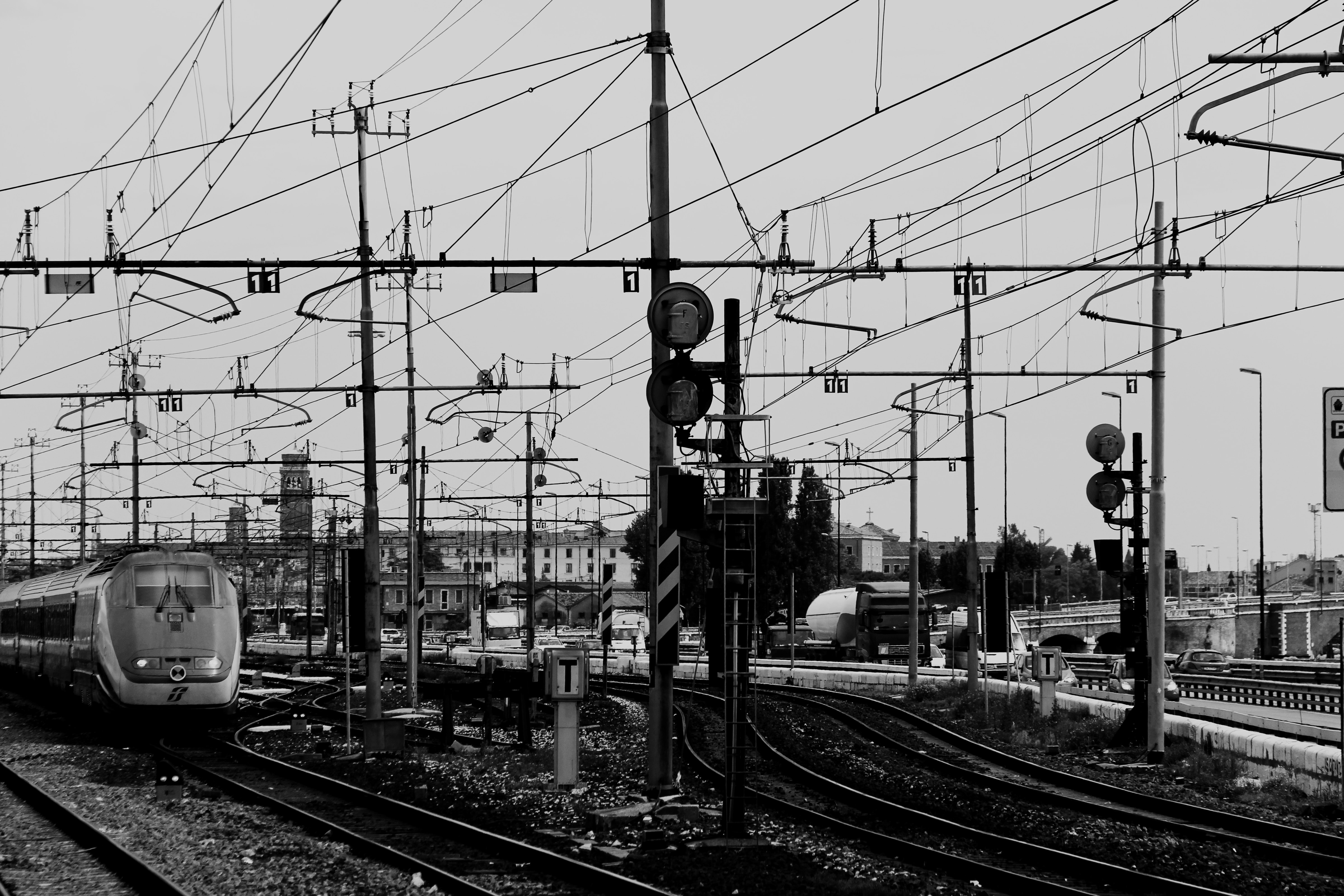 greyscale photo of bullet train and train rails