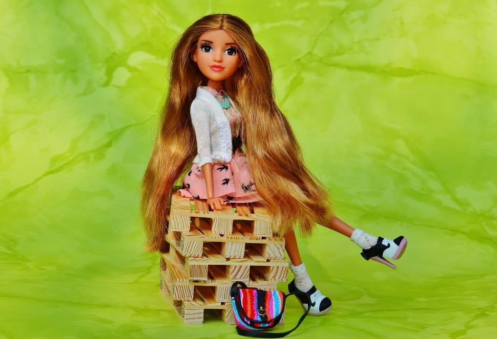 blonde haired doll sitting of wooden pallet preview