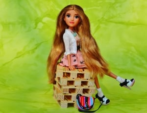 blonde haired doll sitting of wooden pallet thumbnail