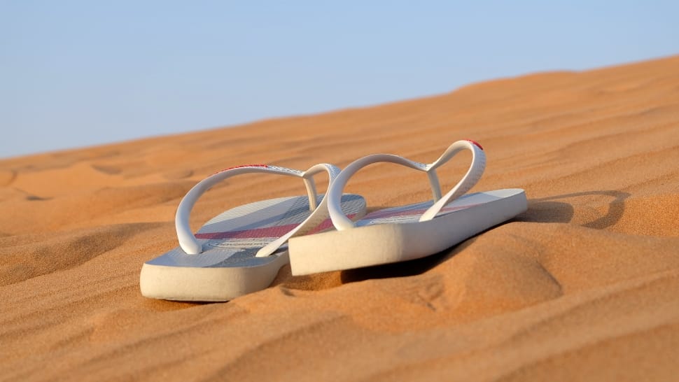 pair of white flip flops preview