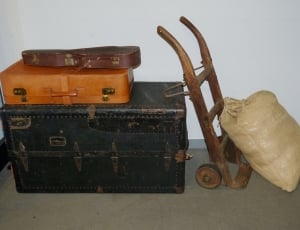 beige sack near brown wooden hand truck and black wooden chest box thumbnail
