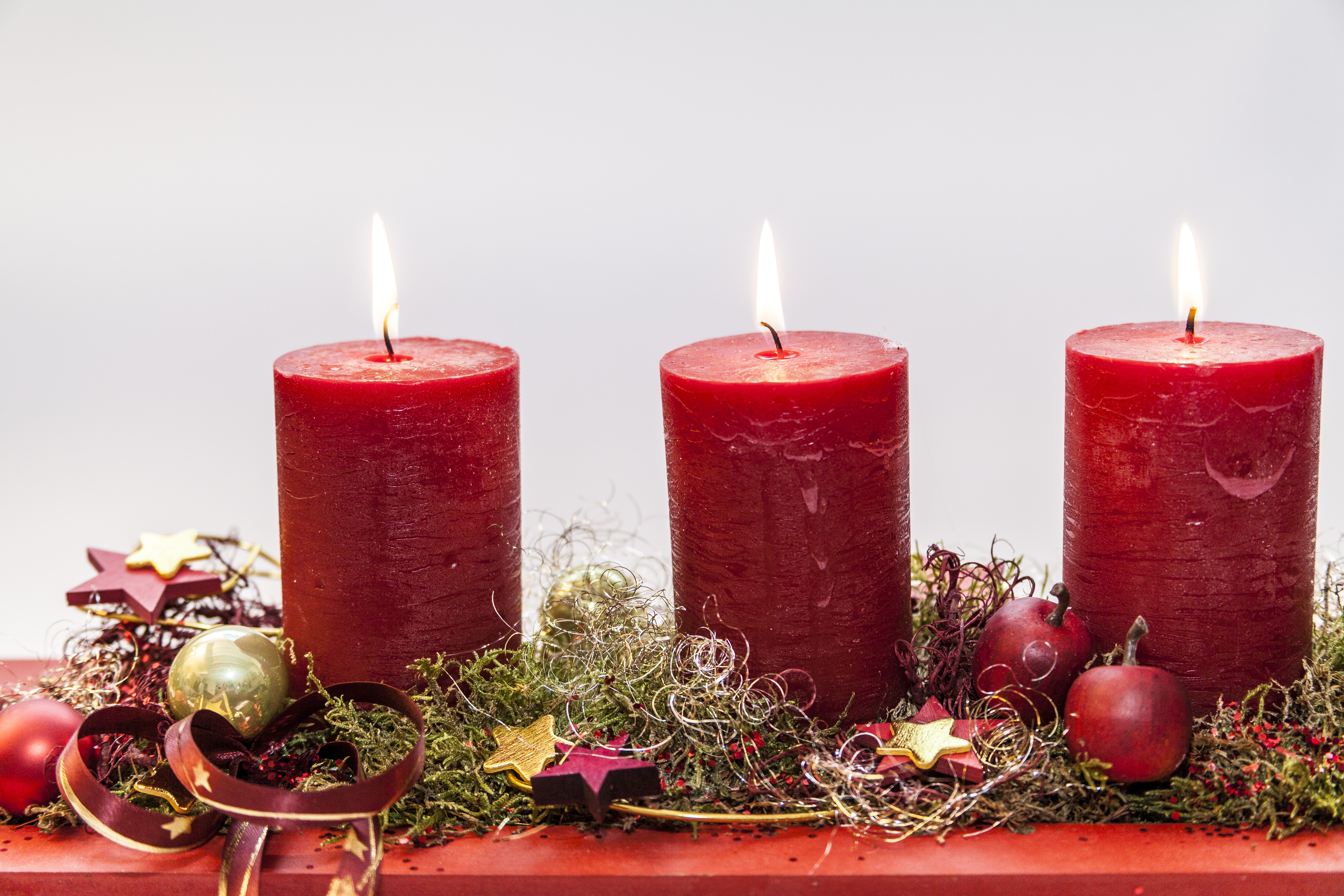 close-up photo of three red pilar candles