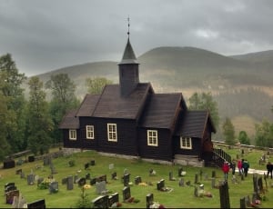 black church in middle of cemetery during cloudy daytime thumbnail