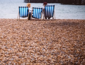 three blue and white picnic chairs on seashore thumbnail
