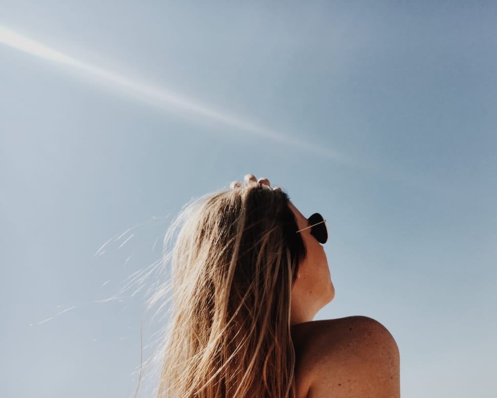 woman in aviator sunglasses looking up in the sky during daytime preview