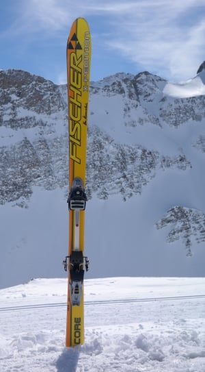 yellow Fischer core ski on the snow coated mountain at daytime thumbnail