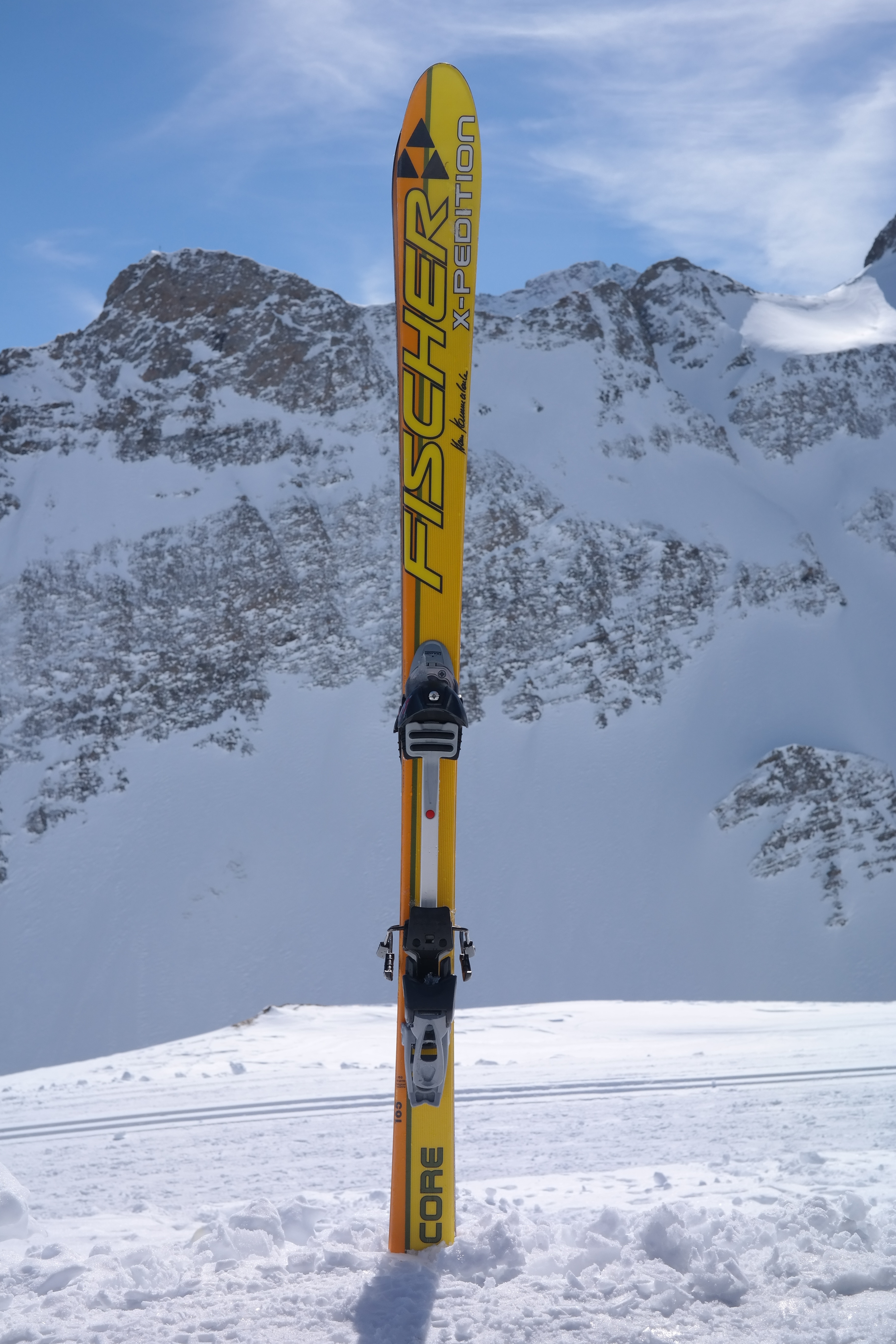 yellow Fischer core ski on the snow coated mountain at daytime