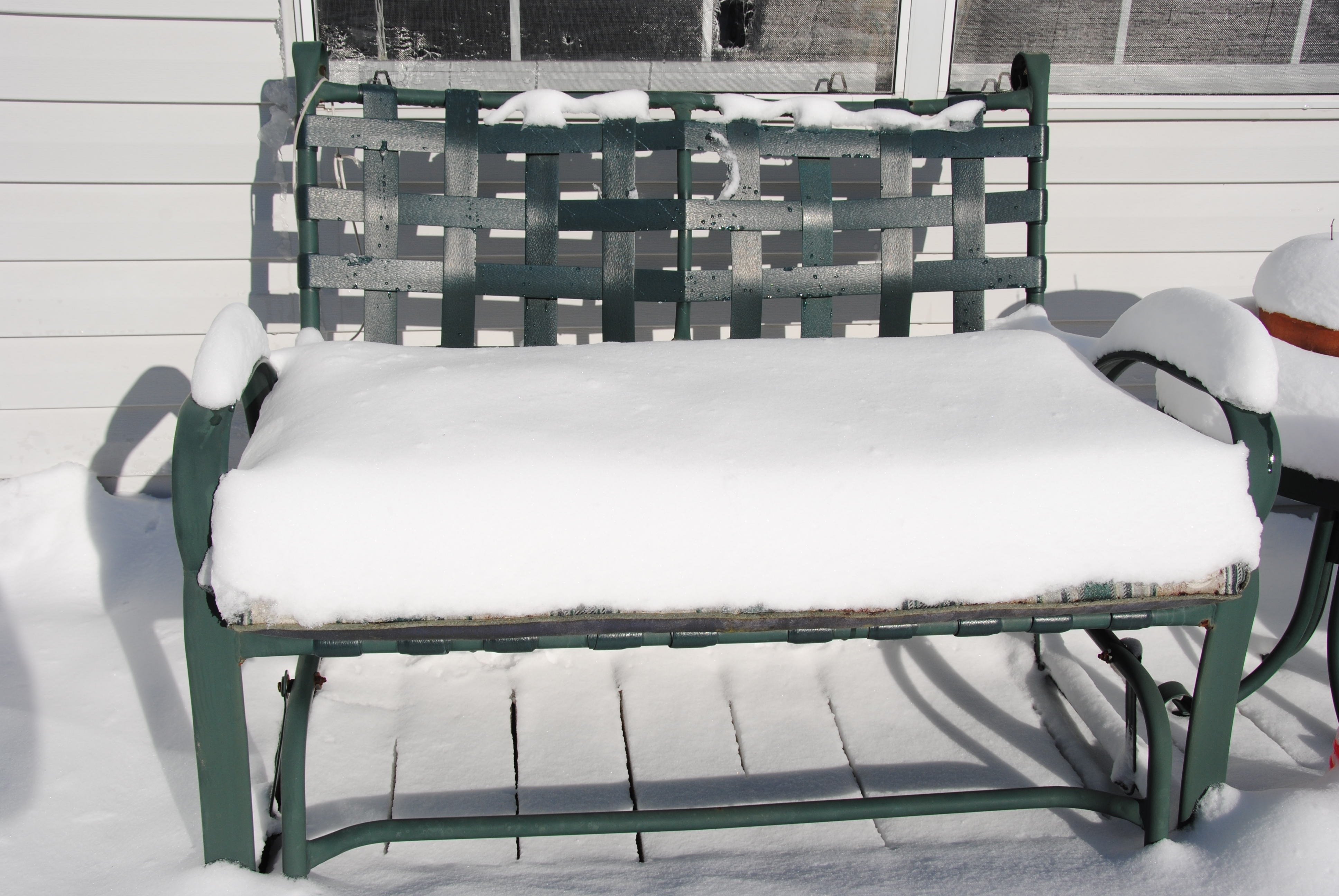 green metal woven base white padded bench with snow