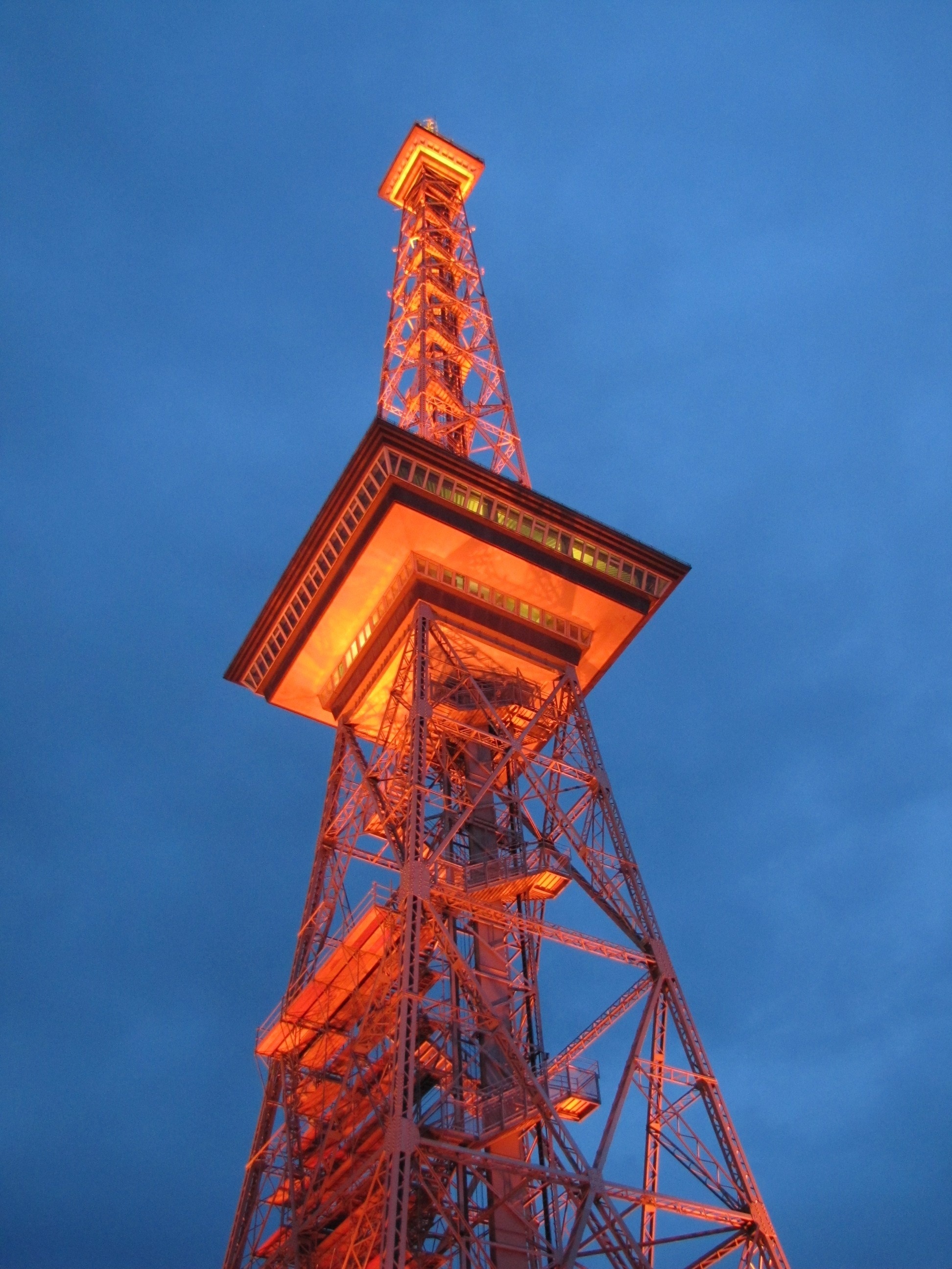 metal tower during dusk with orange lights