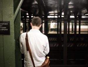 man wearing a white dress shirt waiting at the train station thumbnail