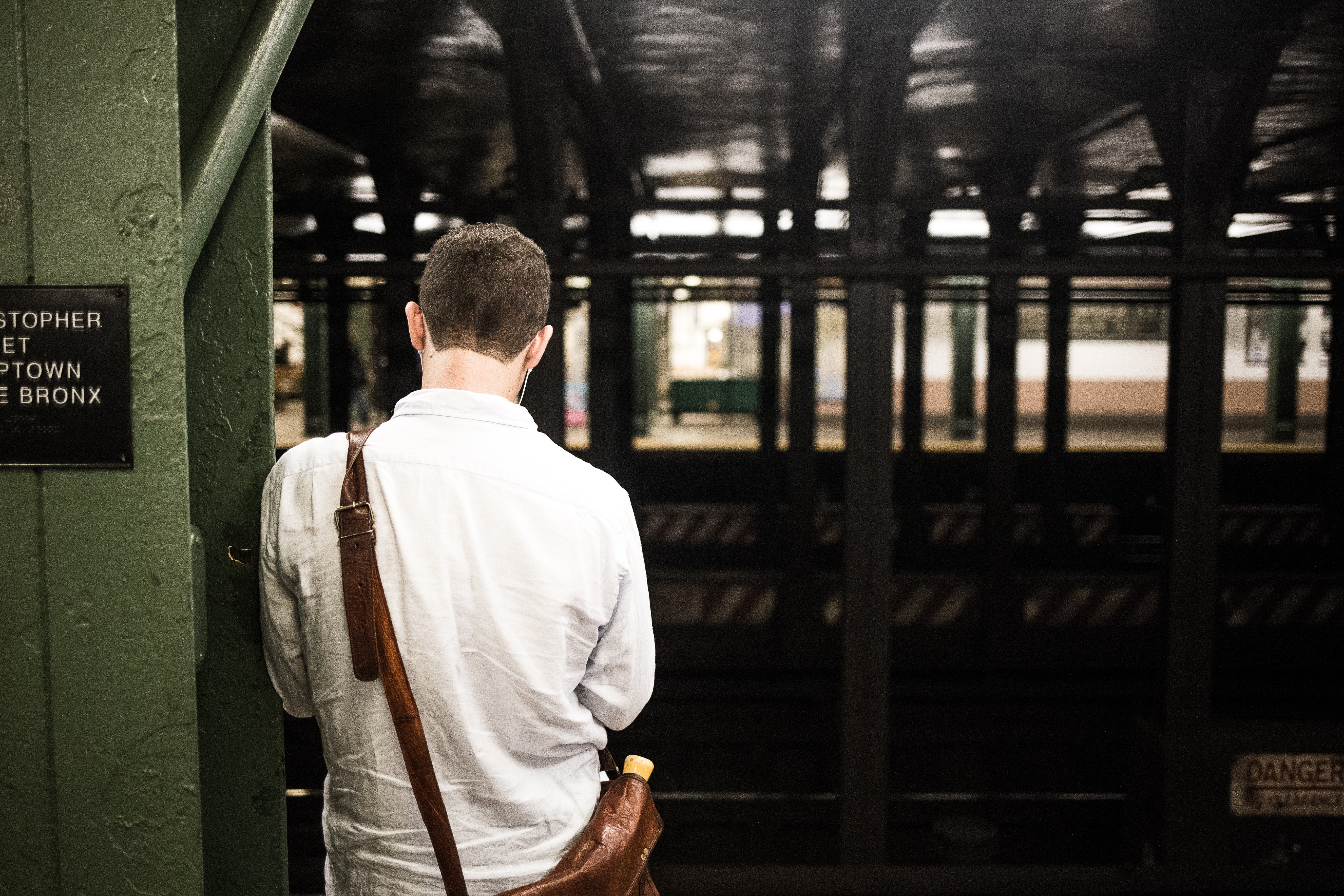 man wearing a white dress shirt waiting at the train station