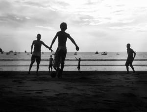 silhouette of boys playing in beach thumbnail