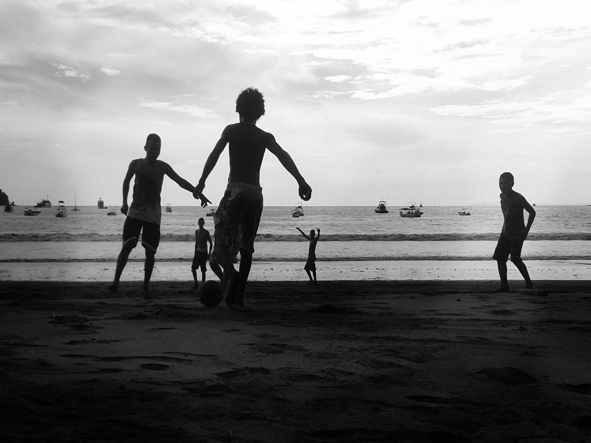silhouette of boys playing in beach