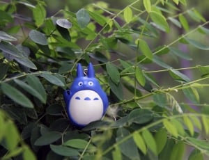 white and blue plastic toy in green leaf tree thumbnail
