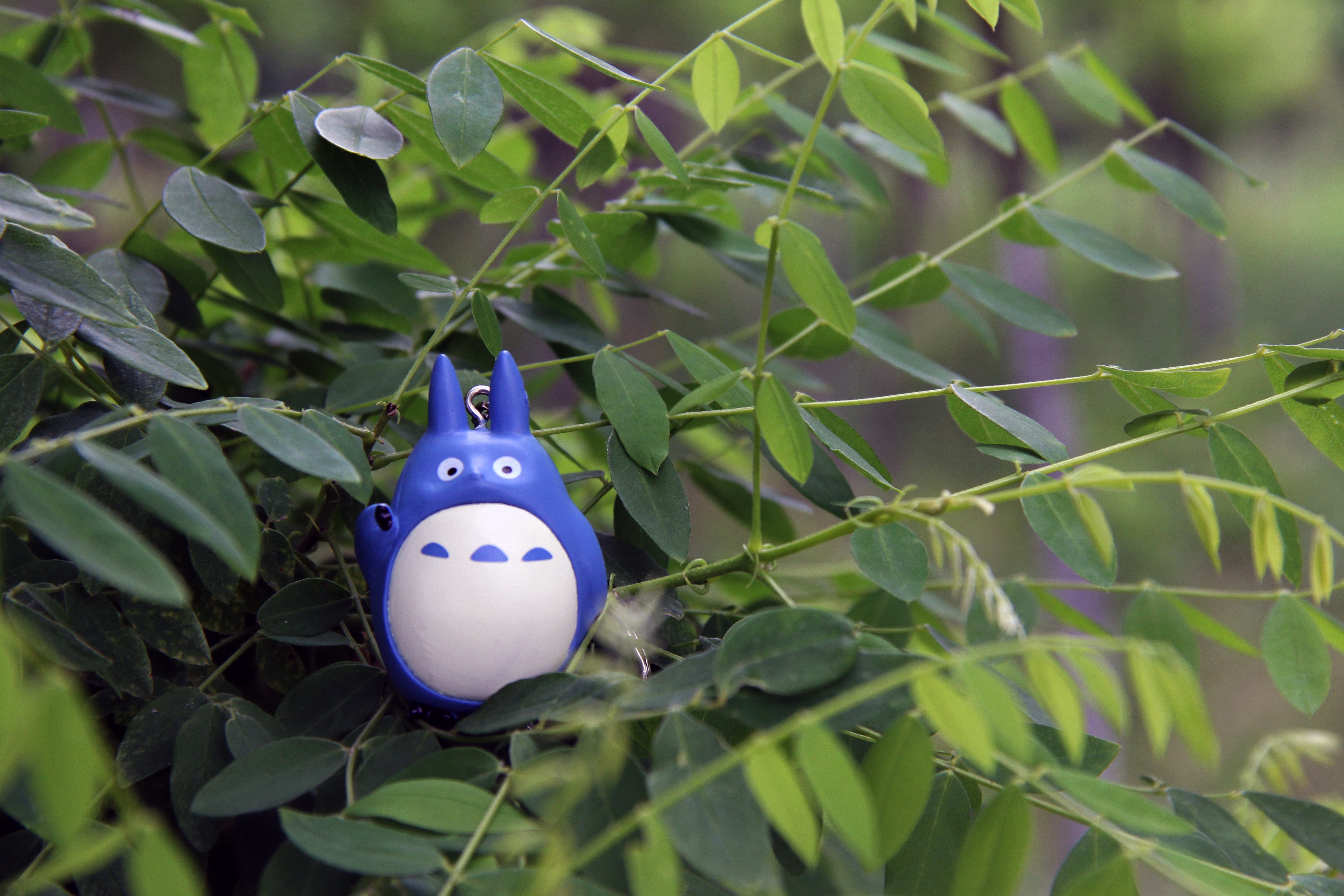 white and blue plastic toy in green leaf tree