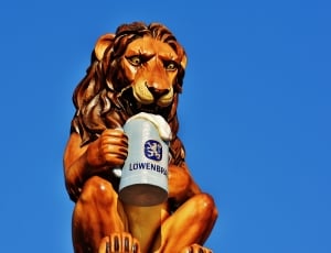 brown and gray lion with mug of beer figurine thumbnail