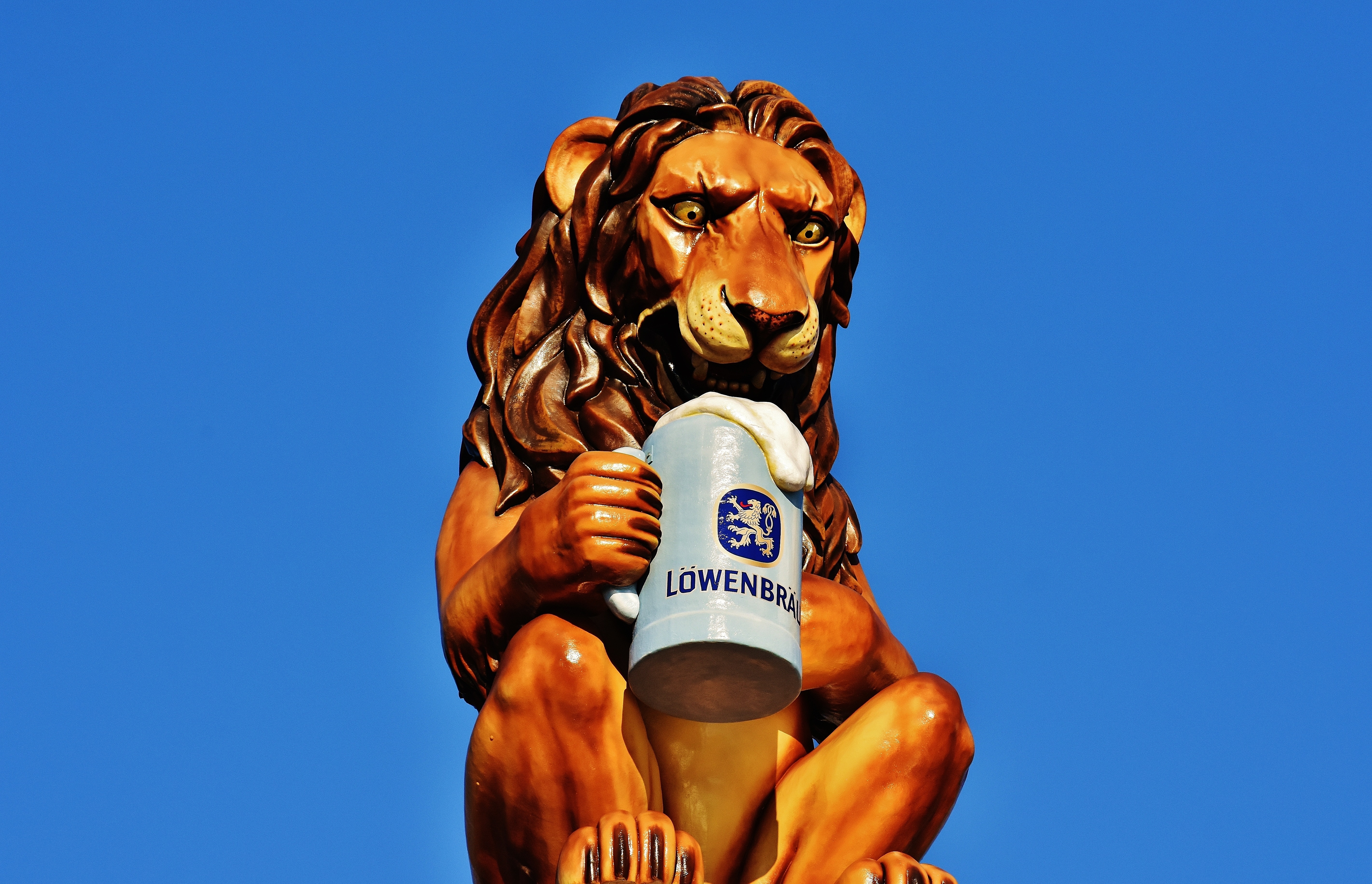 brown and gray lion with mug of beer figurine