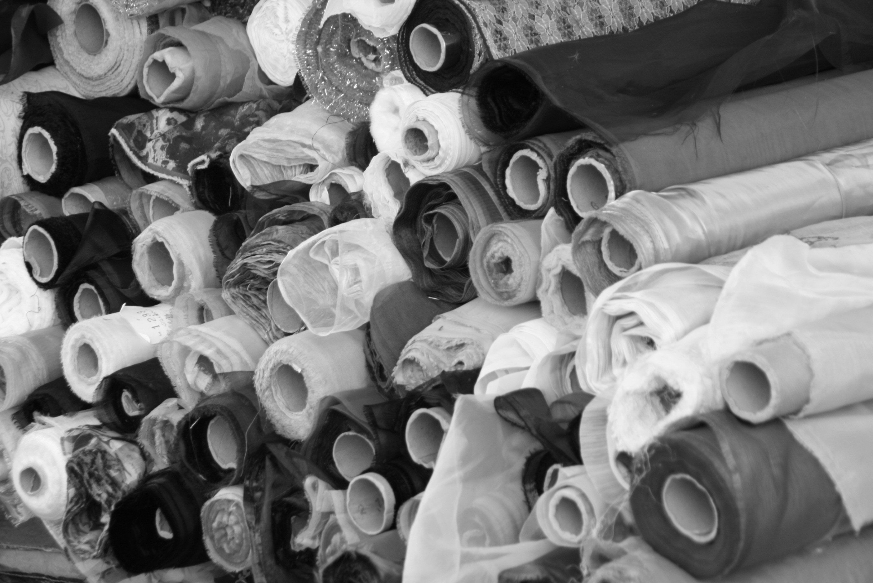 grayscale photo of rolled textile lot