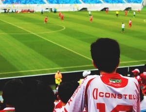 boy in white and red constel jersey in audience stand watching soccer game thumbnail