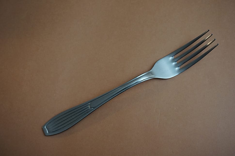 stainless steel fork on top of beige surface preview