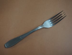 stainless steel fork on top of beige surface thumbnail