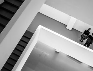 grayscale photography of couple standing near stairs thumbnail