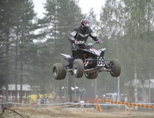 man on a black and red sports atv thumbnail