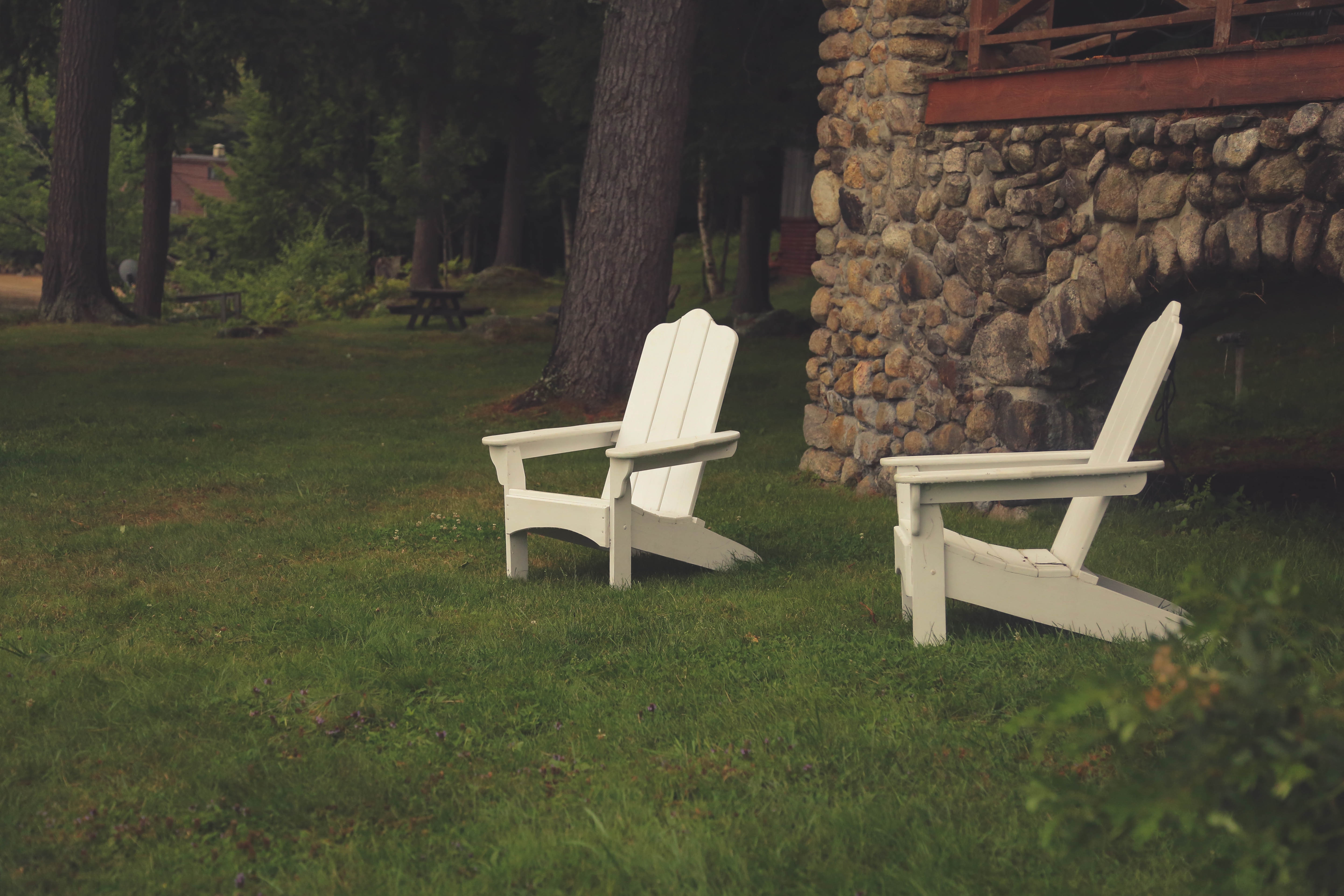 two white wooden adirondack chairs