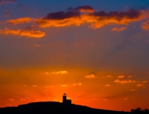 silhouette photo of lighthouse during sunset thumbnail