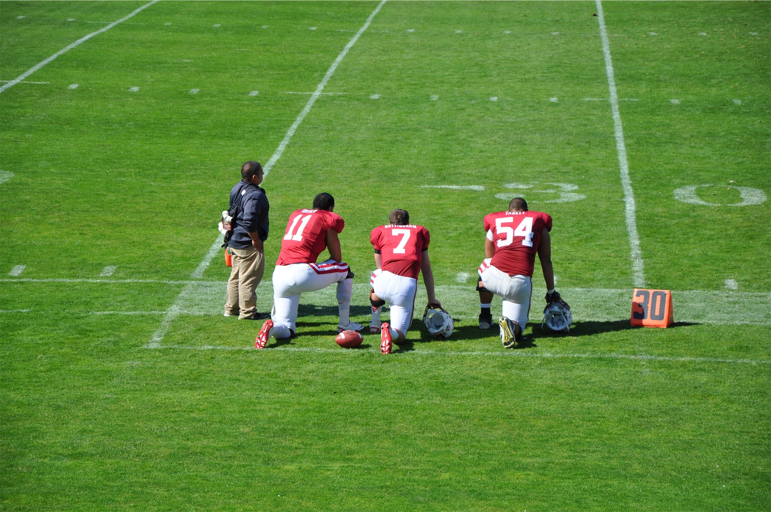 3 football player on field