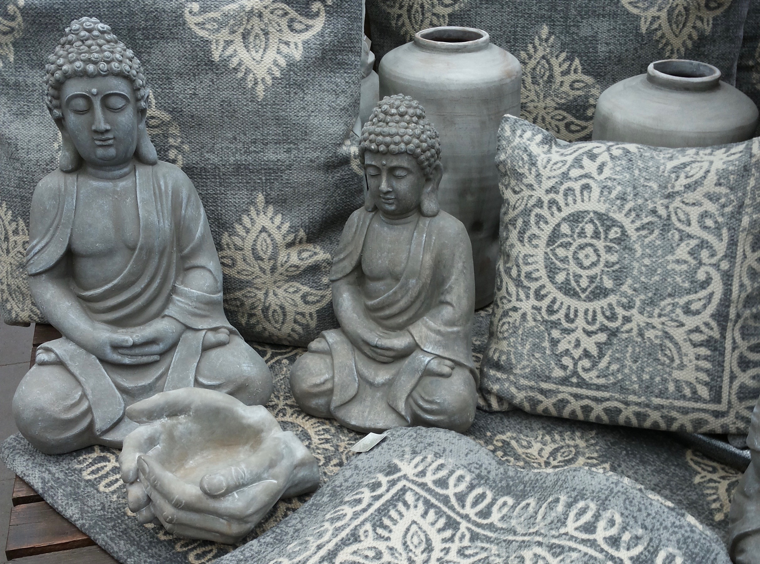2 gray concrete buddha figurines