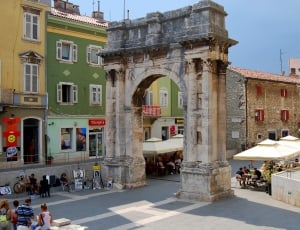 beige and gray concrete arch on the city during daytime thumbnail