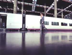 person in suit walking near train cabins thumbnail