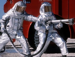 two person wearing silver suit holding spray gun near red truck thumbnail