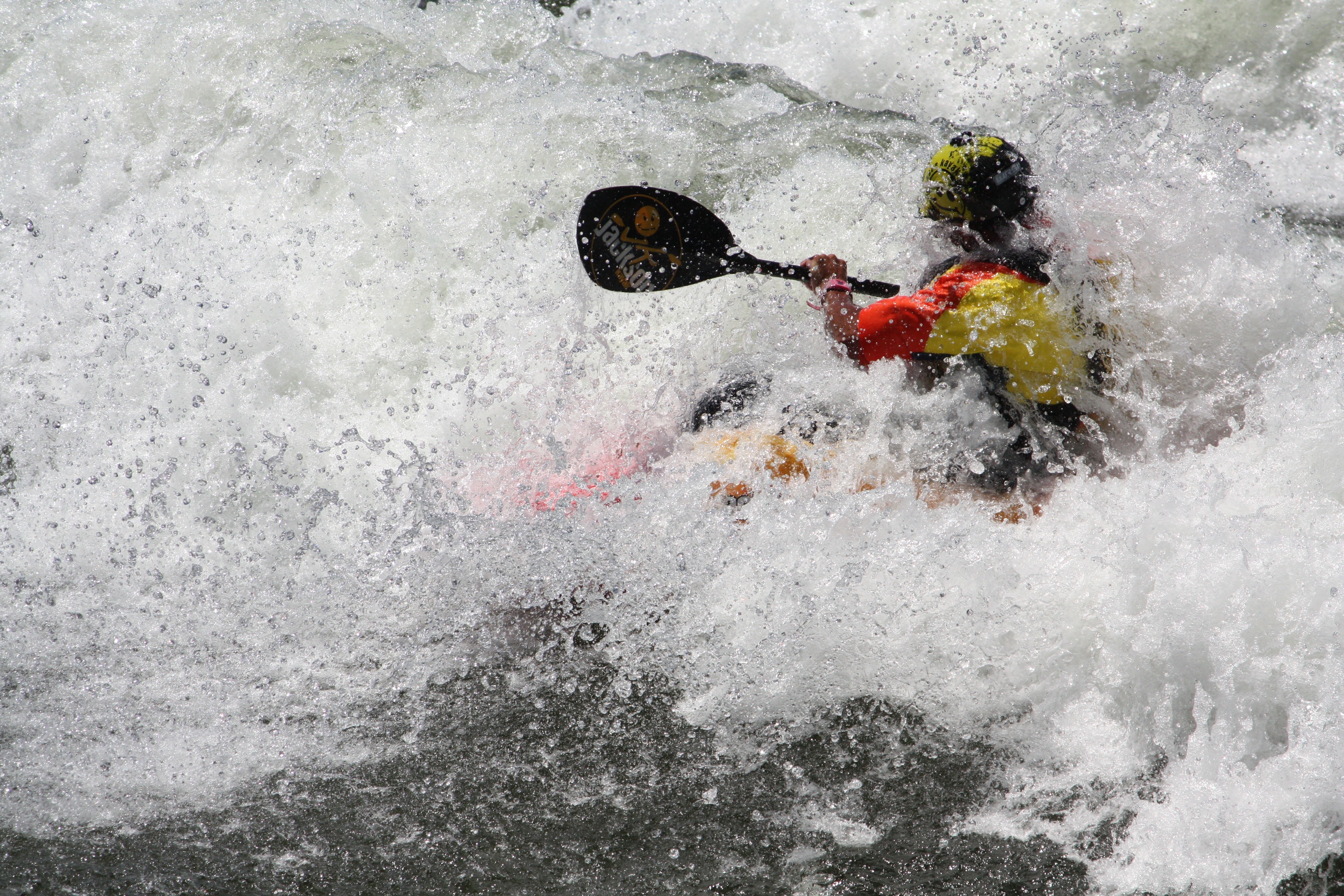 man wearing yellow and red wet suit  while doing activity kayak