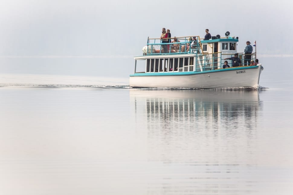 people on teal and white boat preview