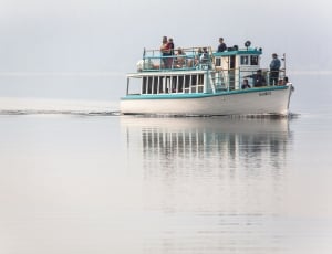 people on teal and white boat thumbnail