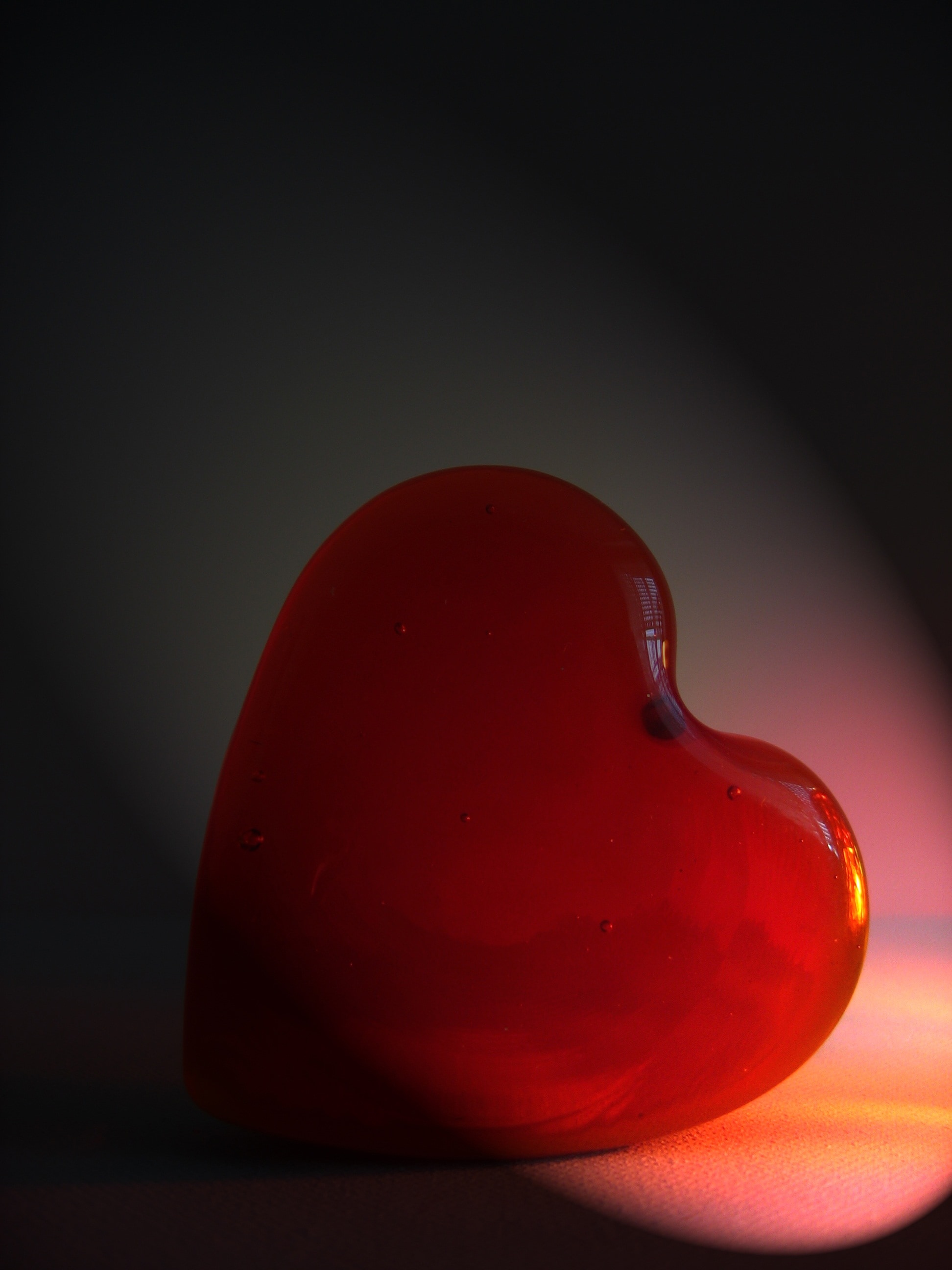 close up of heart shaped stone on white surface