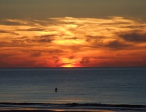 silhouette image of man on the ocean thumbnail