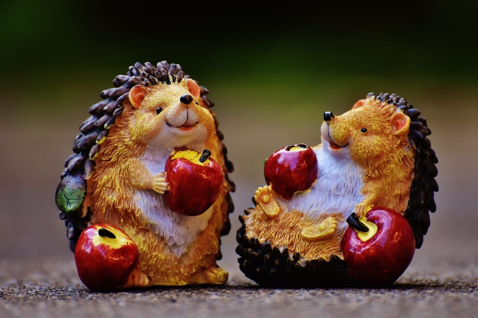 yellow and black hedgehog holding apple figurine preview