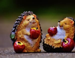 yellow and black hedgehog holding apple figurine thumbnail