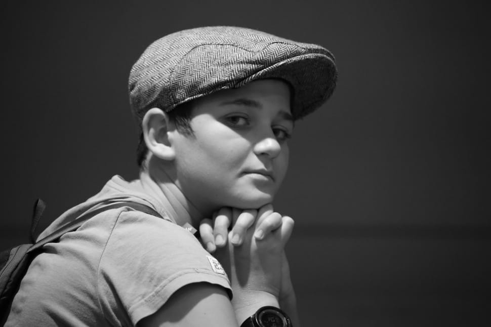 greyscale photography of boy wearing cap sleeve shirt and cap preview