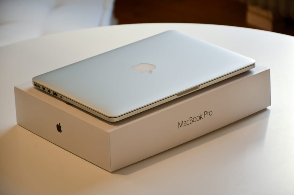 macbook pro with box on round white wooden table preview