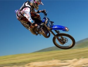 white blue and red motocross suit and blue yamaha motocross dirt bike thumbnail