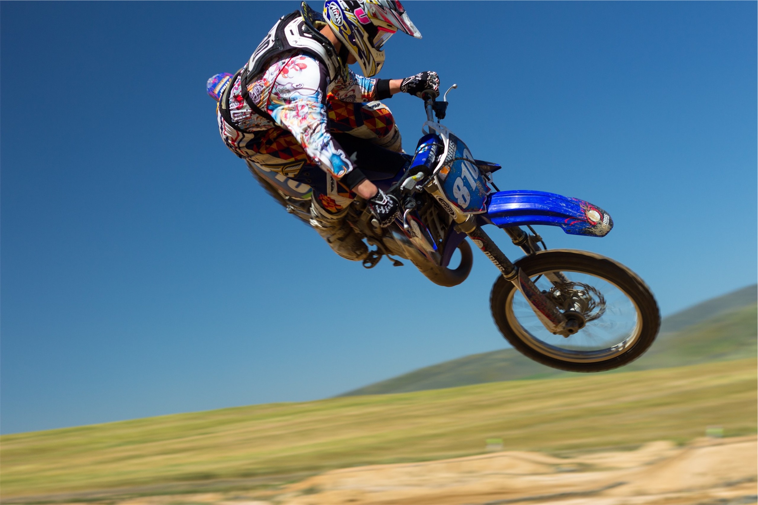 white blue and red motocross suit and blue yamaha motocross dirt bike