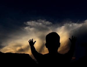silhouette of person when raising his hands thumbnail