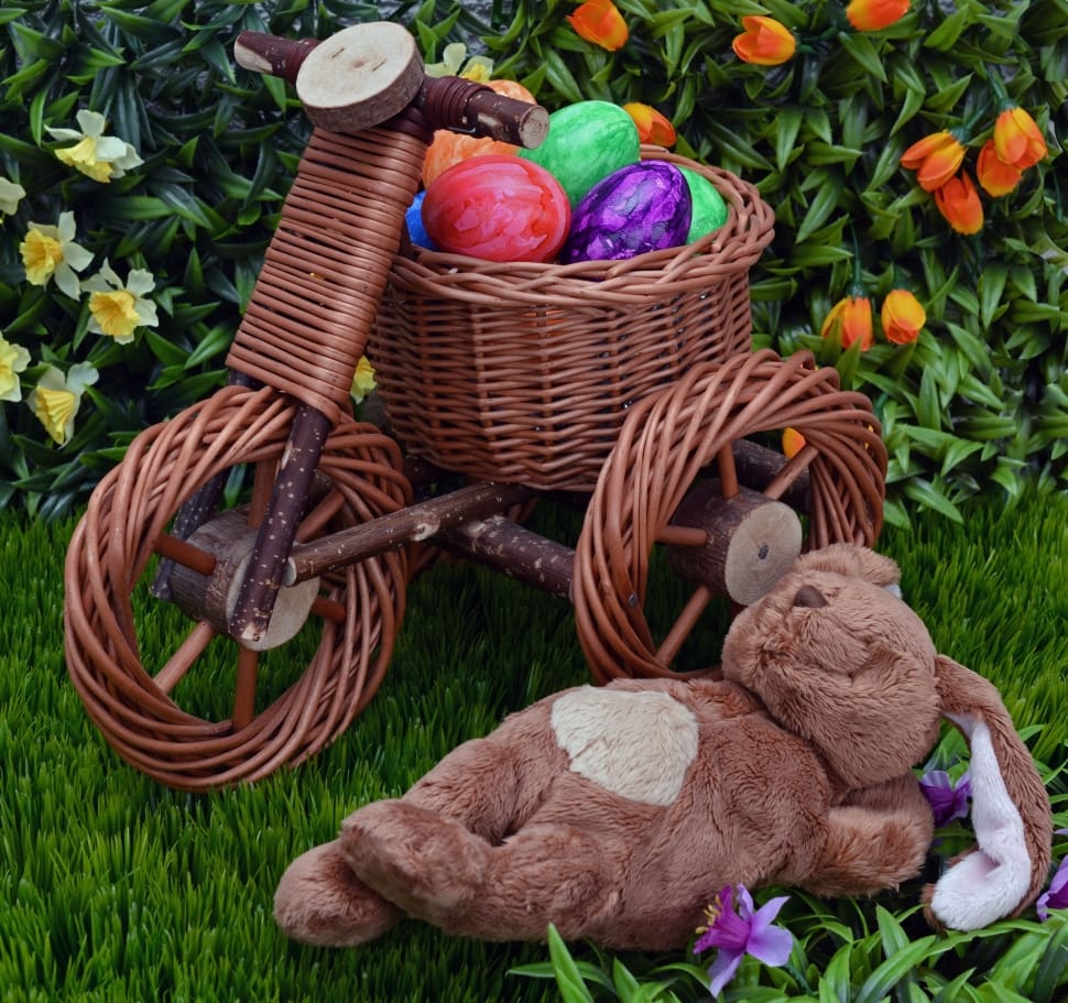 brown rabbit plush toy beside brown wicker trike with easter eggs preview